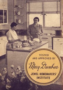 Two women cooking in a vintage kitchen.