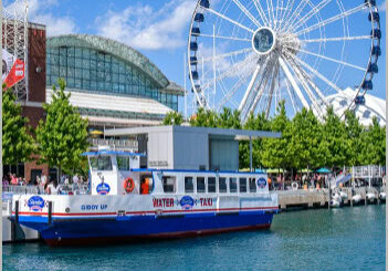 Event-3 Water taxi by Ferris wheel on waterfront.